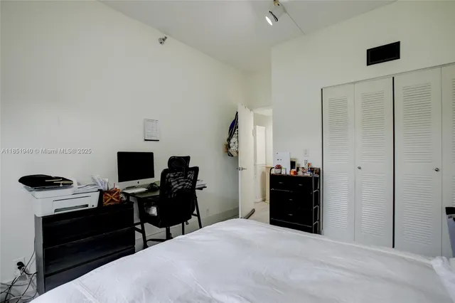 a bedroom with a bed and a flat tv screen on a dresser