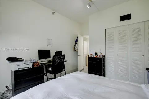 a bedroom with a bed and a flat tv screen on a dresser