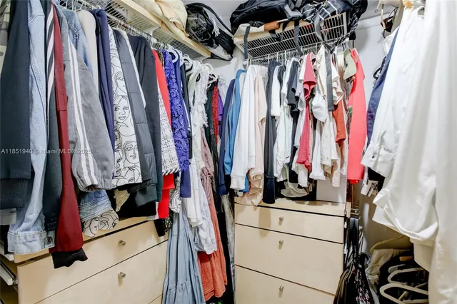 a view of walk in closet with clothes
