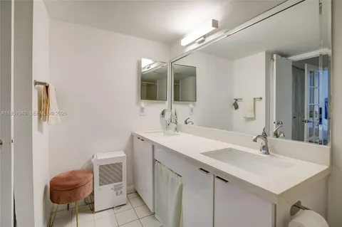 a bathroom with a sink toilet double vanity and shower