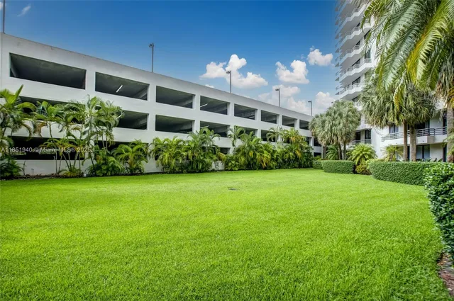 a view of a big yard with potted plants and large trees