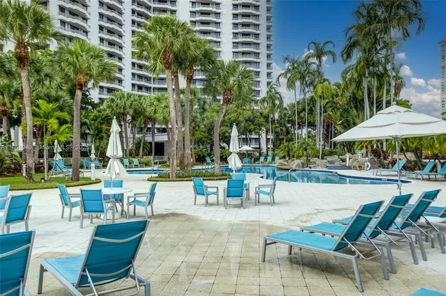 a view of a patio with a table and chairs under an umbrella with potted plants