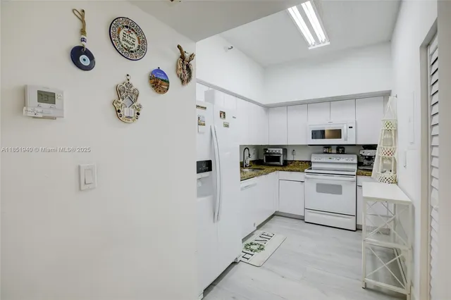 a kitchen with a refrigerator a stove and cabinets