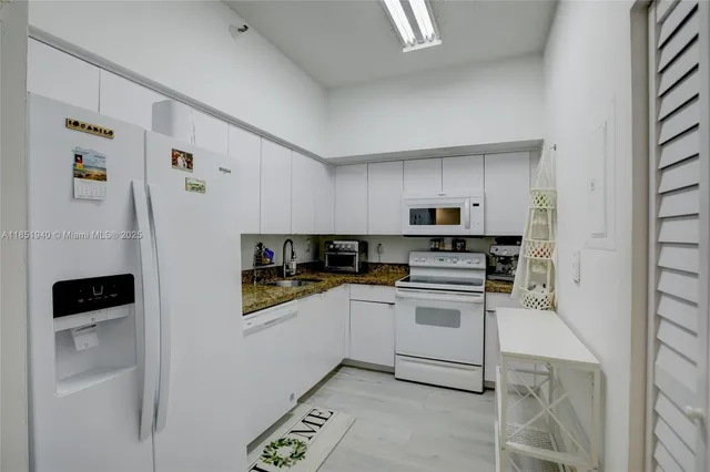 a kitchen with stainless steel appliances granite countertop a refrigerator and a stove top oven
