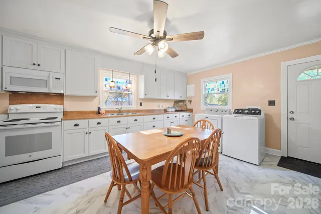 a kitchen with a dining table chairs stainless steel appliances and cabinets
