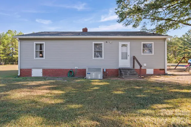 a view of a house with backyard and a tree