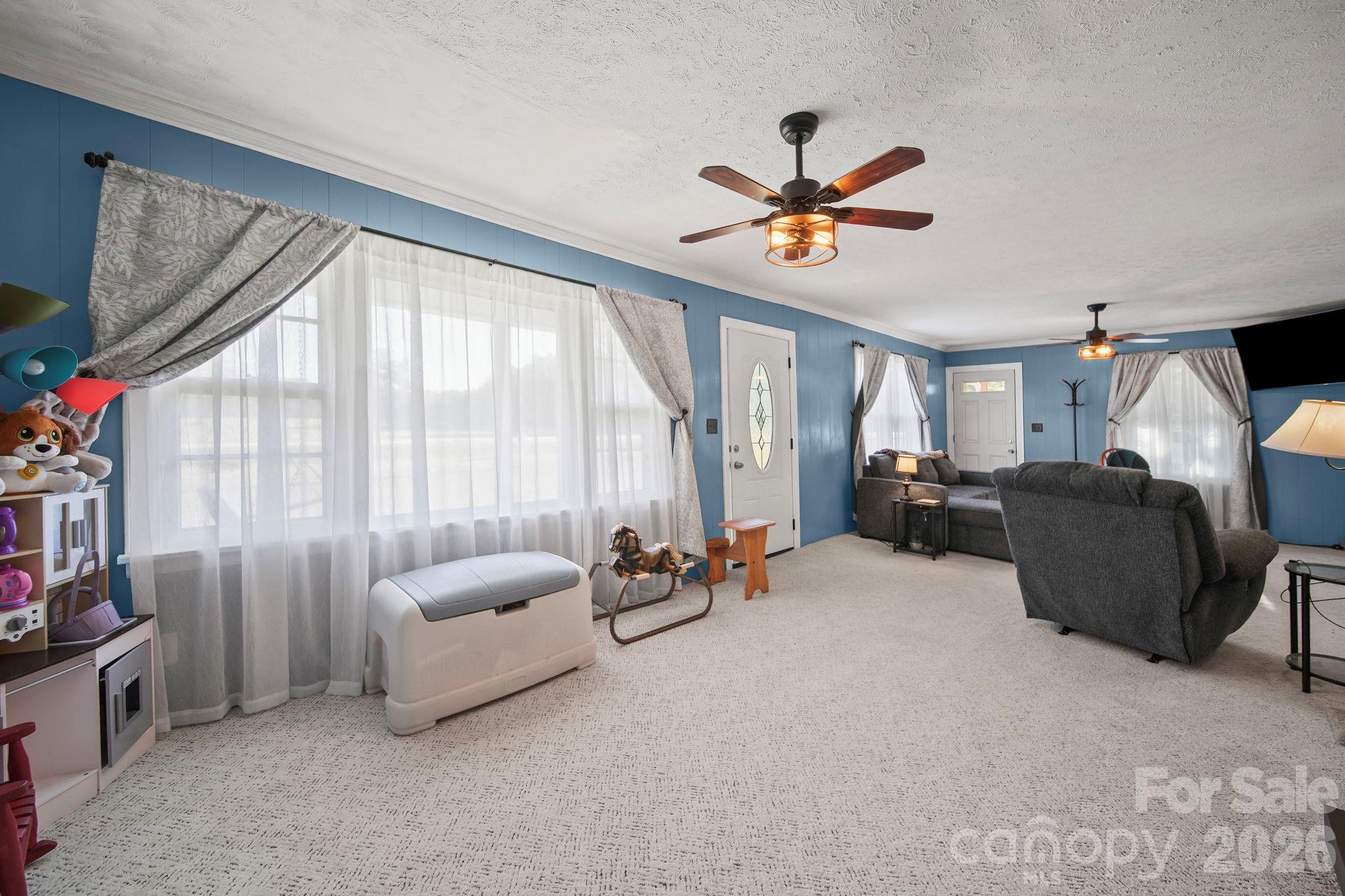 1787 St Johns Church Road Concord, NC 28025 - Photo 10 of 34 a living room with furniture a ceiling fan and a large window