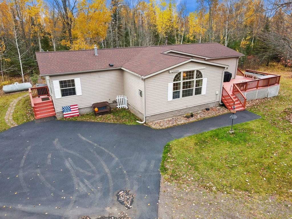 5251 Grabert Road Duluth, MN 55803 - Photo 38 of 50 View of front of house with a wooden deck, roof with shingles, a front yard, and stairs
