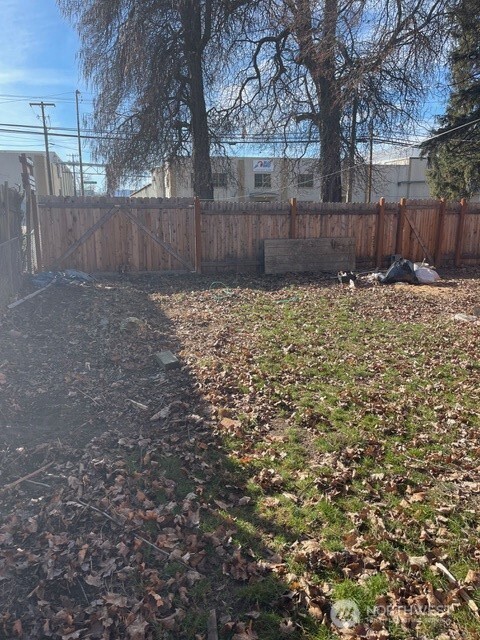 212 West 4th Street Tonasket, WA 98855 - Photo 23 of 24 a view of a backyard with large trees and wooden fence