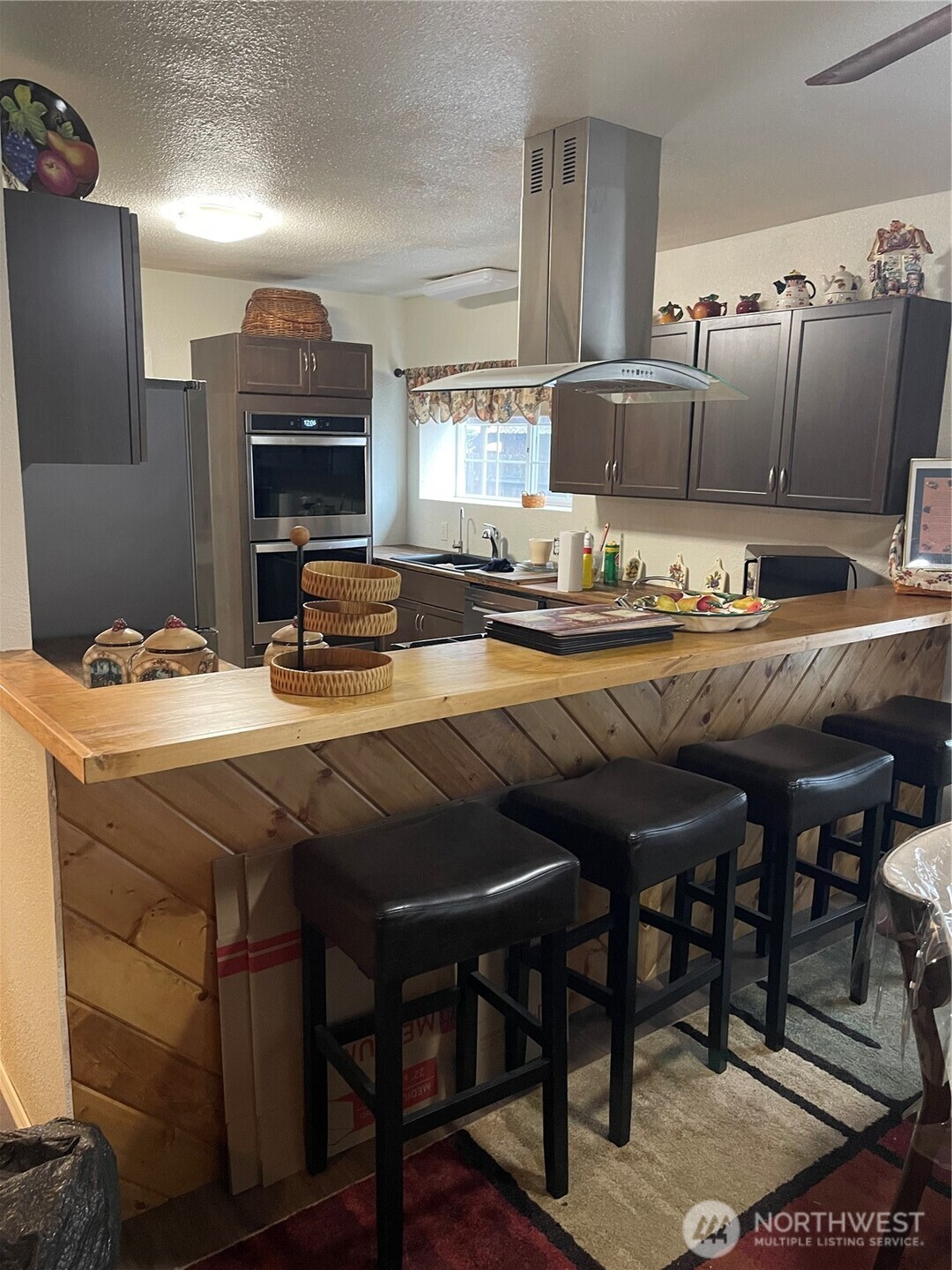212 West 4th Street Tonasket, WA 98855 - Photo 10 of 24 a kitchen with a table chairs and a refrigerator