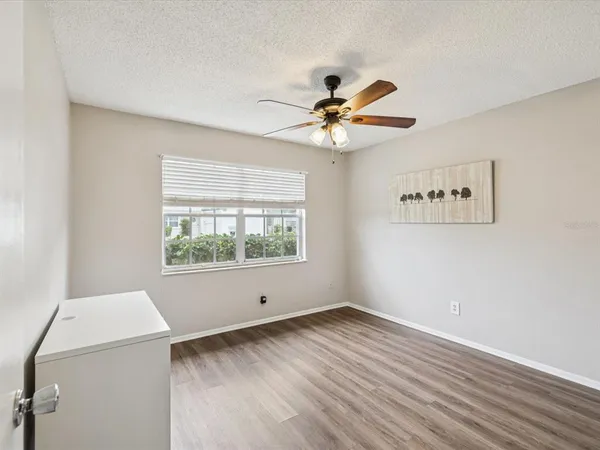 a view of an empty room with a window and a ceiling fan