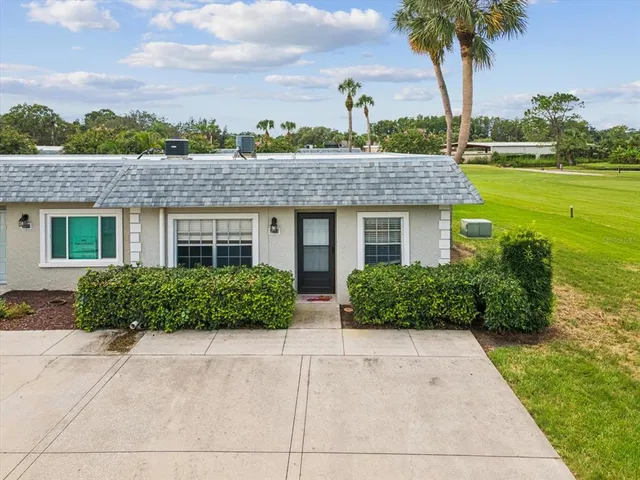 a front view of a house with a yard and potted plants