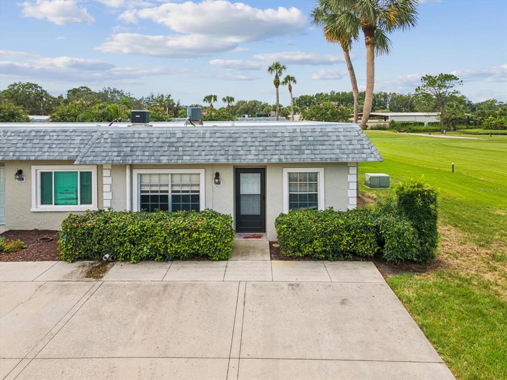 3683 Trophy Boulevard, Unit 7 New Port Richey, FL 34655 - Photo 2 of 42 a front view of a house with a yard and potted plants