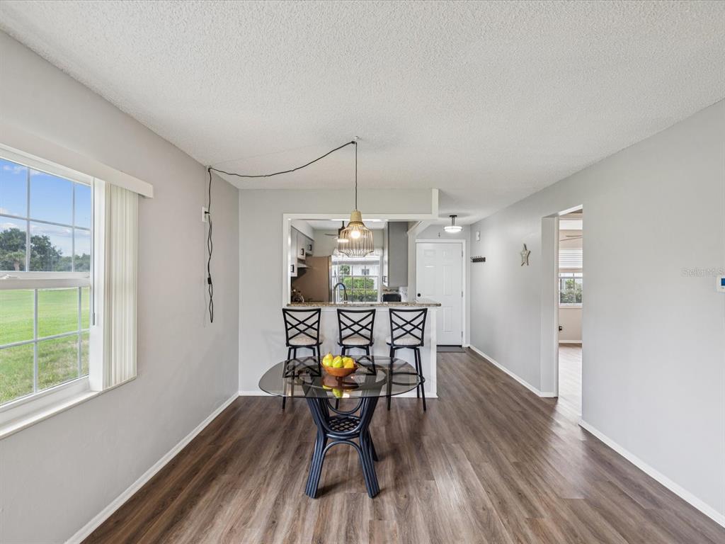 3683 Trophy Boulevard, Unit 7 New Port Richey, FL 34655 - Photo 5 of 42 a view of a dining room with furniture window and wooden floor