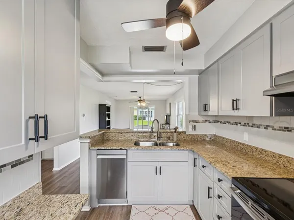 a kitchen with stainless steel appliances granite countertop a sink stove and cabinets