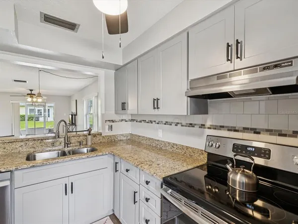 a kitchen with a stove and white cabinets