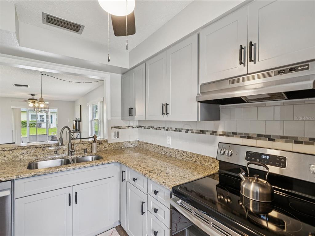 3683 Trophy Boulevard, Unit 7 New Port Richey, FL 34655 - Photo 9 of 42 a kitchen with a stove and white cabinets