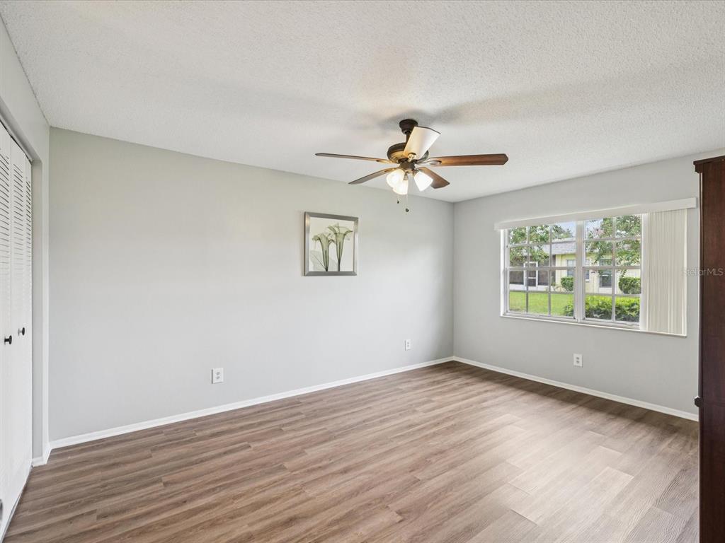 3683 Trophy Boulevard, Unit 7 New Port Richey, FL 34655 - Photo 10 of 42 a view of an empty room with wooden floor and a window