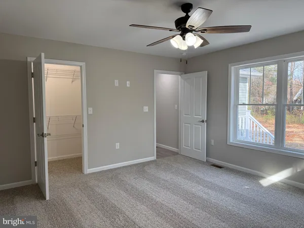 an empty room with a window and a fan