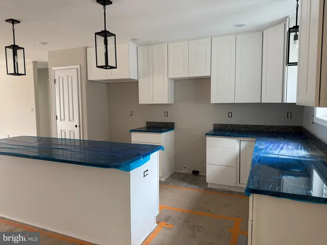 a kitchen with granite countertop a sink and cabinets