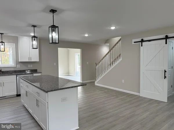 a kitchen with granite countertop a sink stainless steel appliances and cabinets