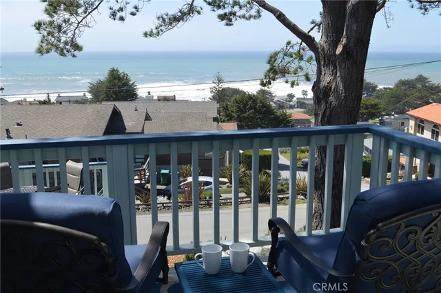 a view of a balcony with chairs and a potted plant