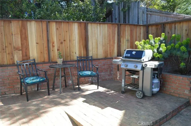 a backyard of a house with barbeque oven table and chairs