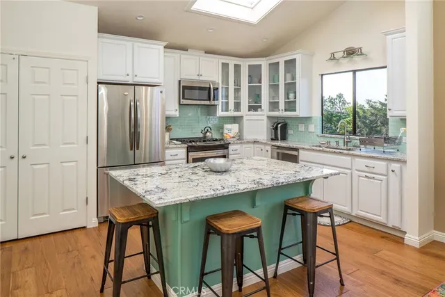 a kitchen with stainless steel appliances granite countertop a stove a refrigerator a sink dishwasher with a dining table and chairs