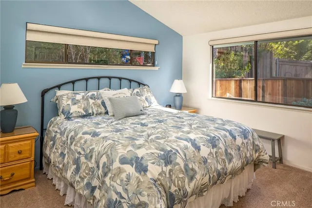 a large bed sitting in a bedroom next to a window