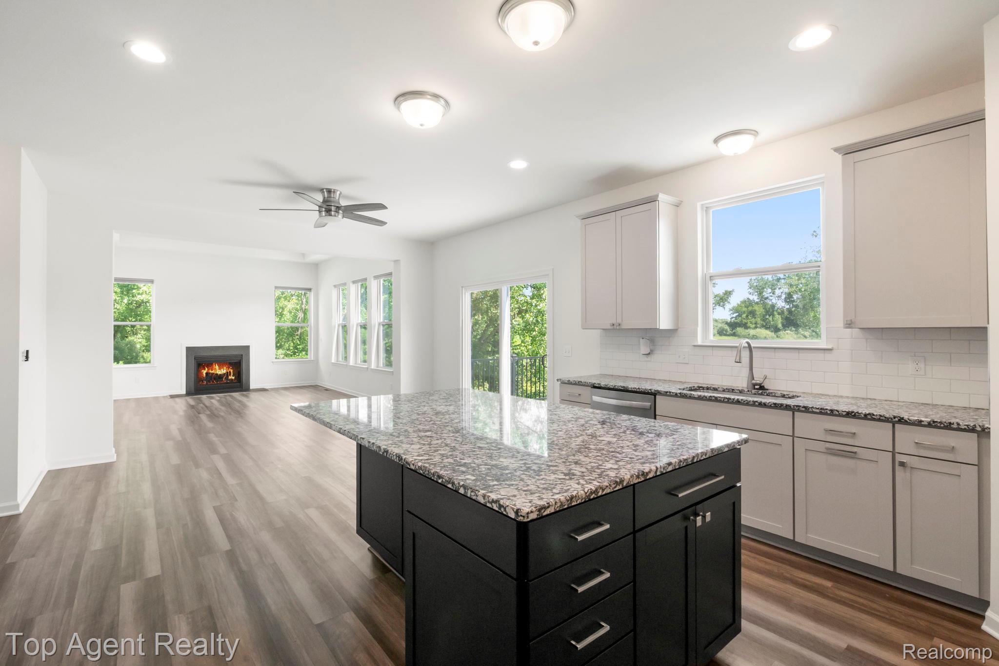 63770 Dequindre Road Washington, MI 48095 - Photo 21 of 61 Kitchen featuring a dark-toned island with a light-toned patterned countertop, light-toned cabinetry, and a white subway tile backsplash