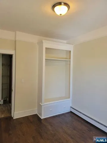 an empty room with wooden floor and closet
