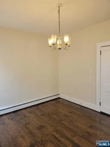 a view of a room with wooden floor and chandelier