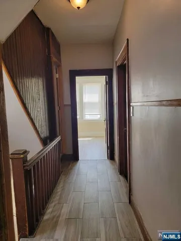 a view of a hallway with wooden floor and staircase