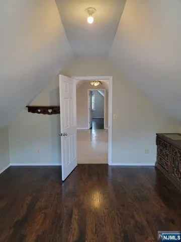 an empty room with wooden floor and mirror