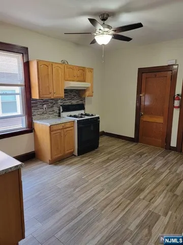 a view of a kitchen with wooden floor and a ceiling fan