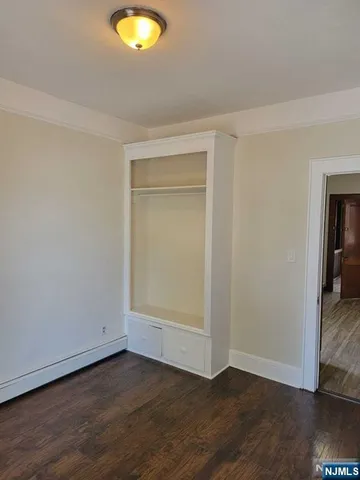 an empty room with wooden floor and closet