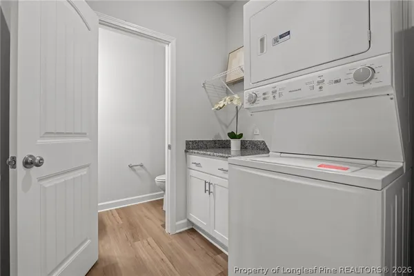 a kitchen with stainless steel appliances granite countertop a sink a stove a refrigerator and white cabinets