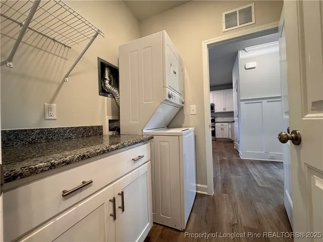 a kitchen with granite countertop a refrigerator and a stove top oven