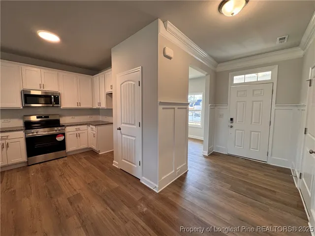 a large kitchen with a center island and wooden floor