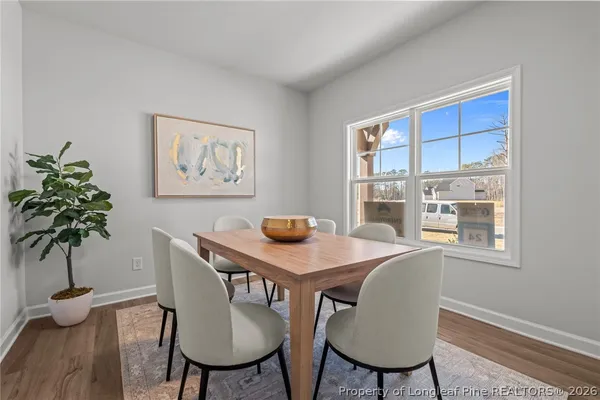 a kitchen with stainless steel appliances granite countertop a stove top oven a sink dishwasher and a refrigerator with wooden floor