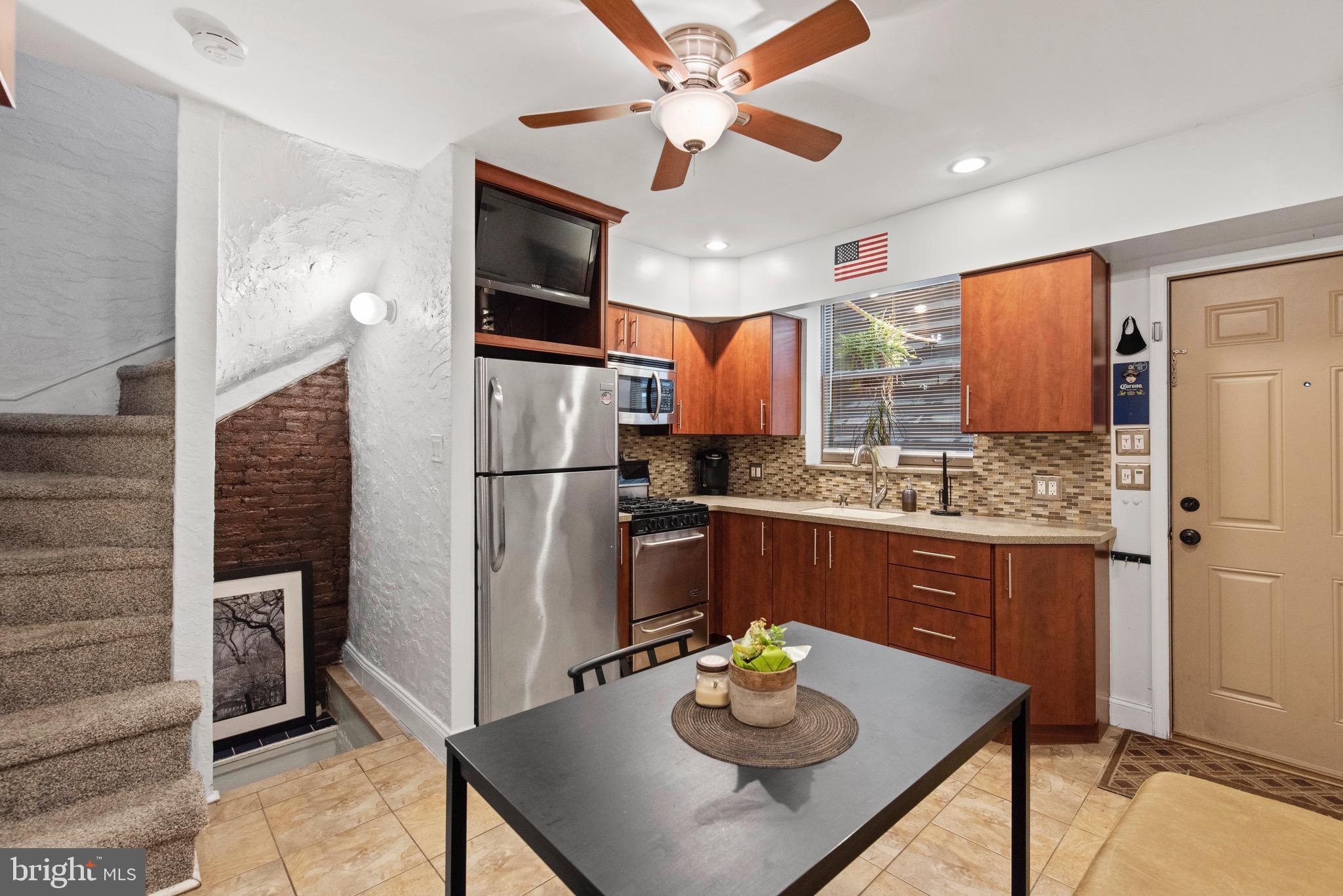 a kitchen with stainless steel appliances kitchen island granite countertop a refrigerator a stove and a sink