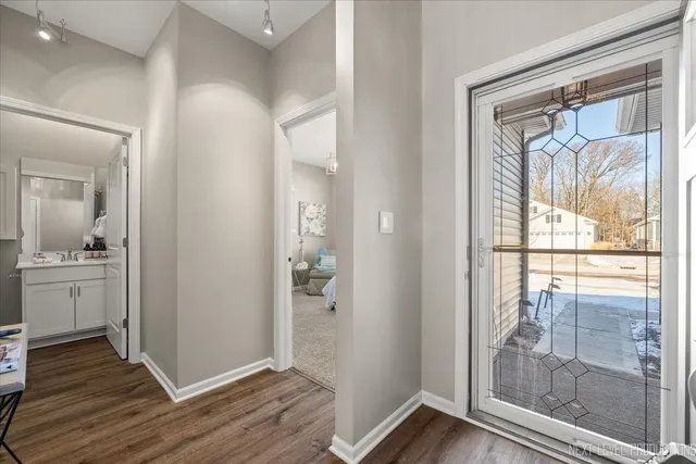 a view of a hallway with wooden floor and a living room