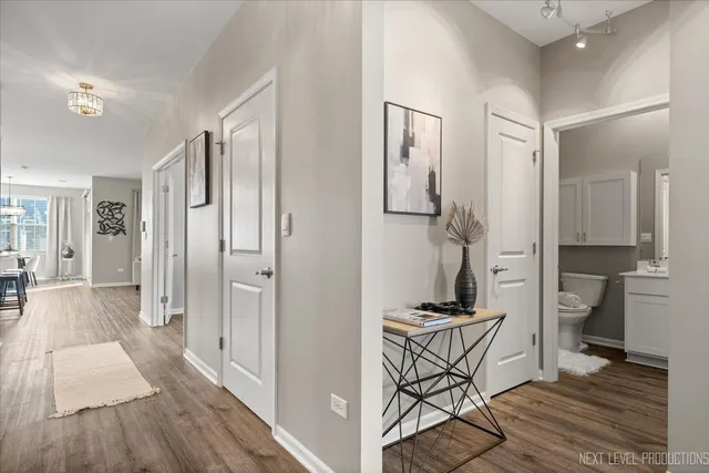 a kitchen with stainless steel appliances granite countertop a stove top oven a sink a dining table and chairs with wooden floor