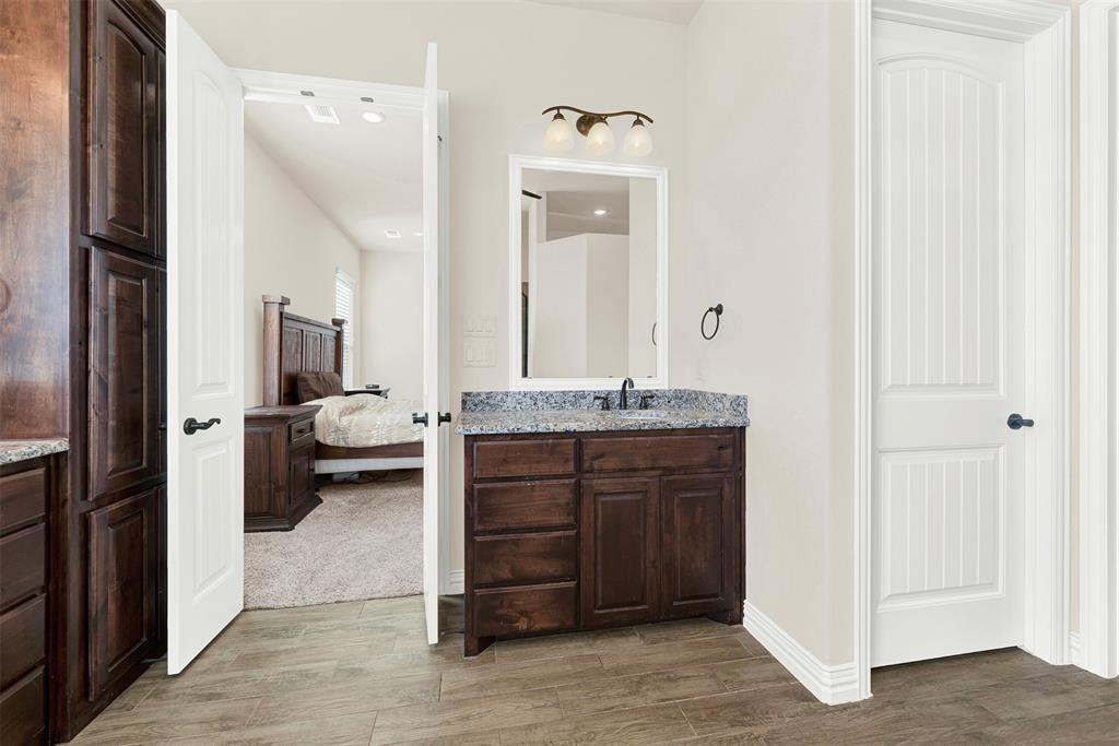 834 Audra Circle Rhome, TX 76078 - Photo 11 of 33 a bathroom with a granite countertop sink a mirror and a toilet