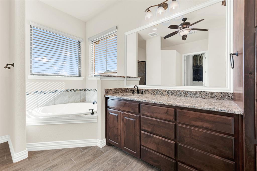 834 Audra Circle Rhome, TX 76078 - Photo 12 of 33 a bathroom with a tub a sink and a large mirror