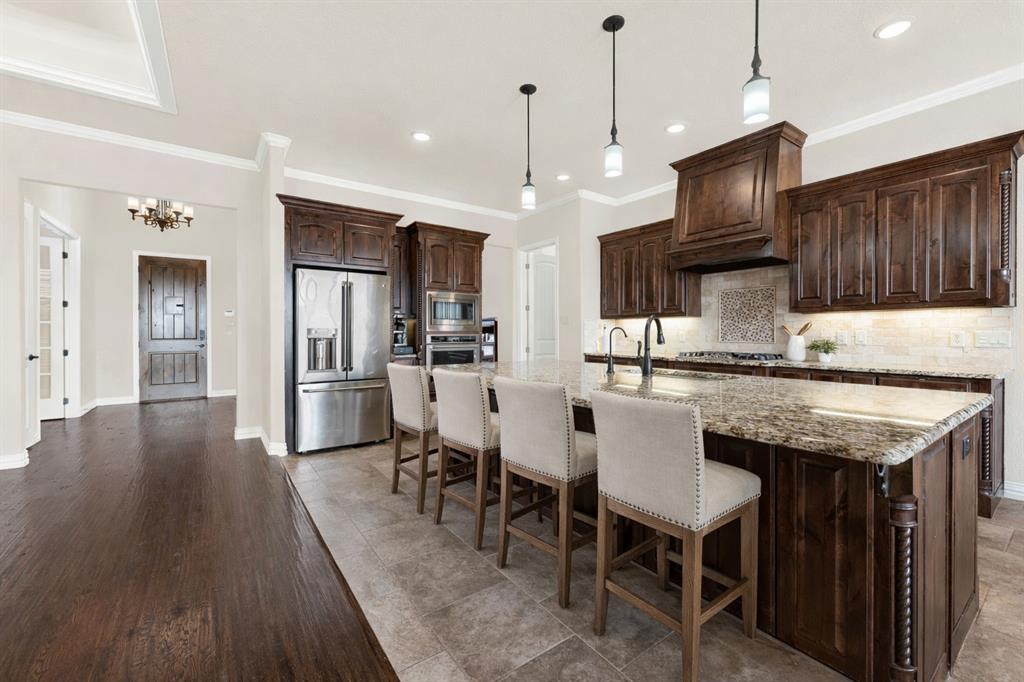 834 Audra Circle Rhome, TX 76078 - Photo 5 of 33 a kitchen with granite countertop a table chairs refrigerator and a sink