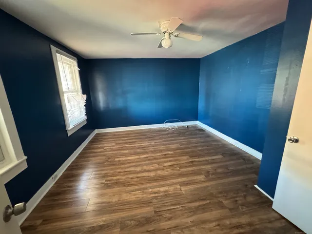 a view of empty room with window and wooden floor