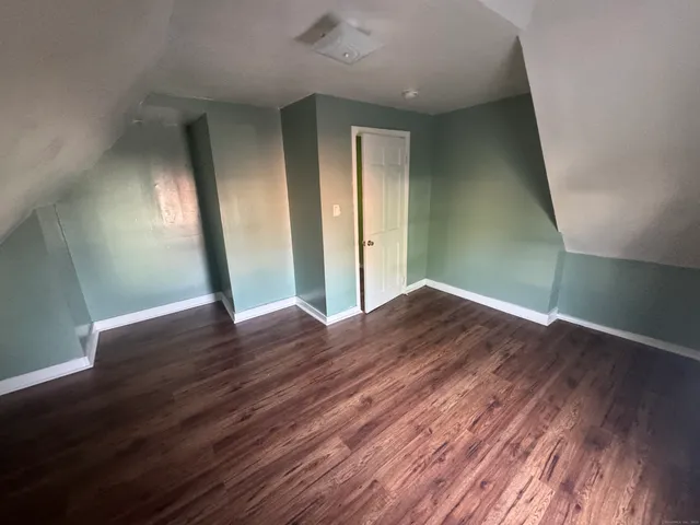 an empty room with wooden floor and entrance