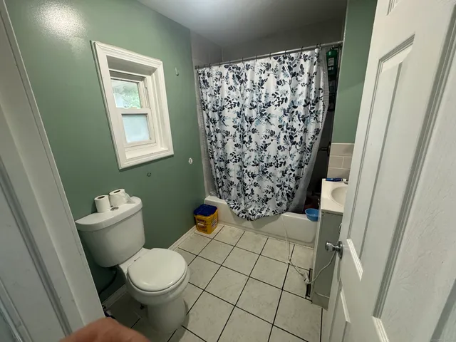 a bathroom with a toilet and a shower curtain