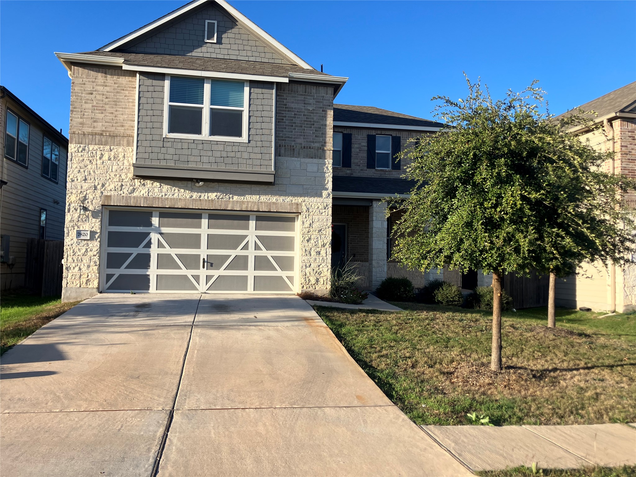 View of front of home with a front yard, driveway, and an attached garage